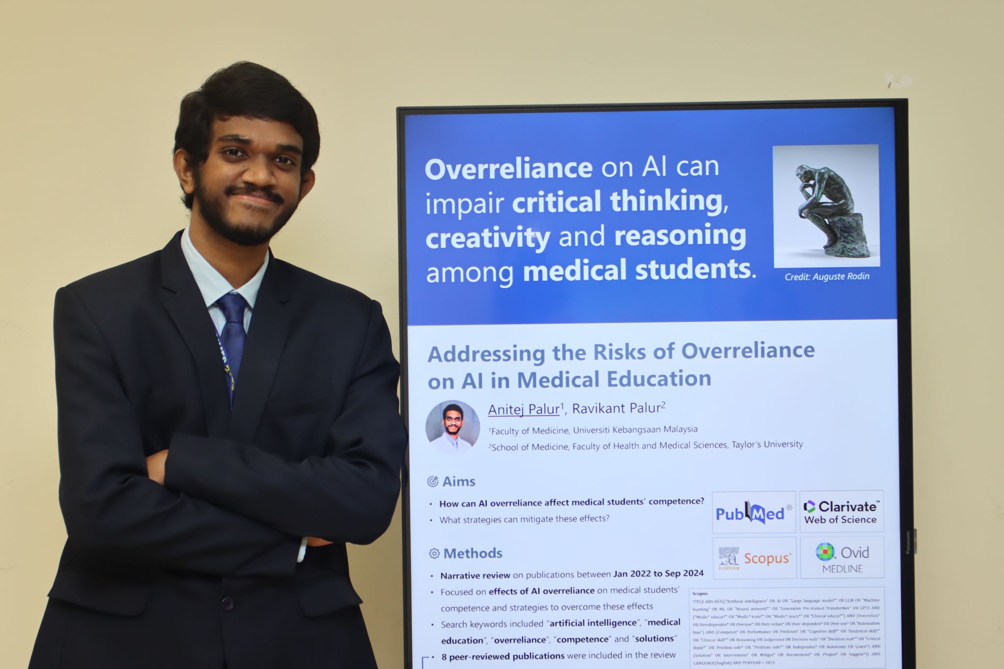 Anitej standing next to his poster.