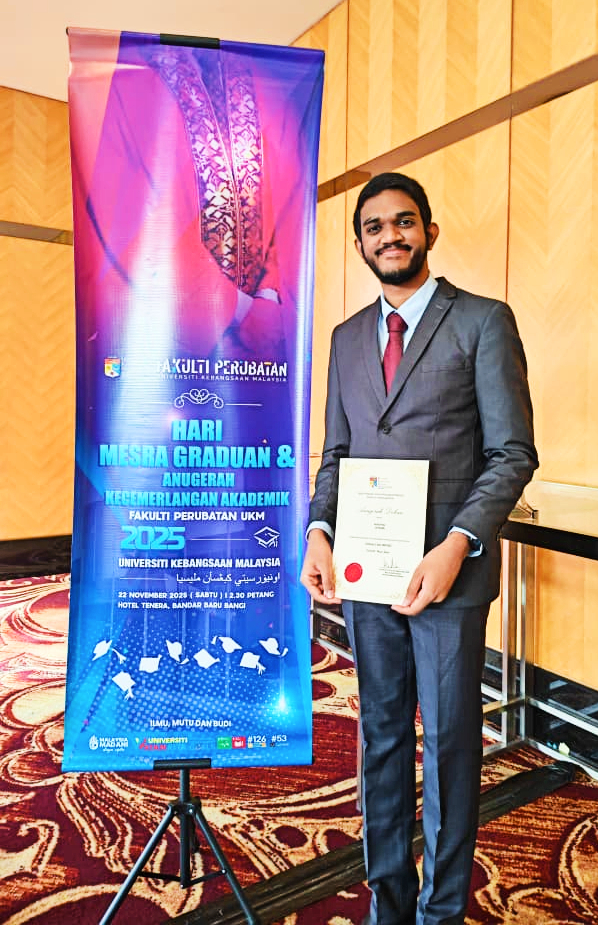 Anitej holding his Dean's Award.